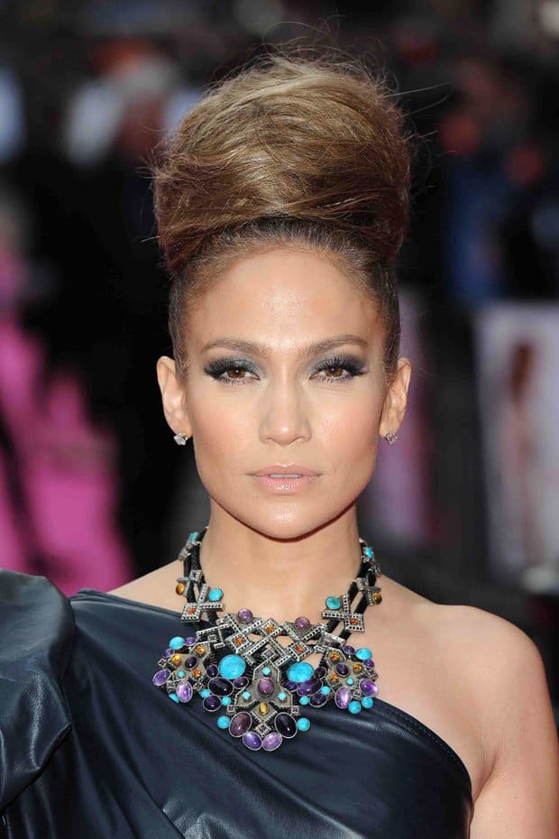 Jennifer Lopez styled her hair in an elegant updo, complemented by dramatic smokey eye makeup and a stunning statement necklace adorned with vibrant gemstones