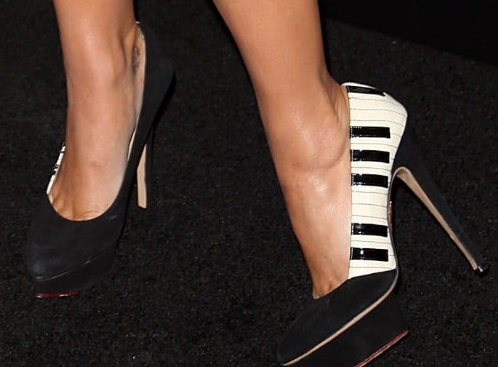 Katy Perry's shoes are black and white high heels featuring a unique piano-keyboard design on the sides, adding a playful and musical touch to her ensemble