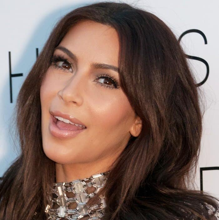 Kim Kardashian tries to smile at the Grand Opening of DASH Miami Beach