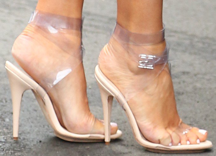 Kim Kardashian's feet in ugly sandals featuring clear plastic straps