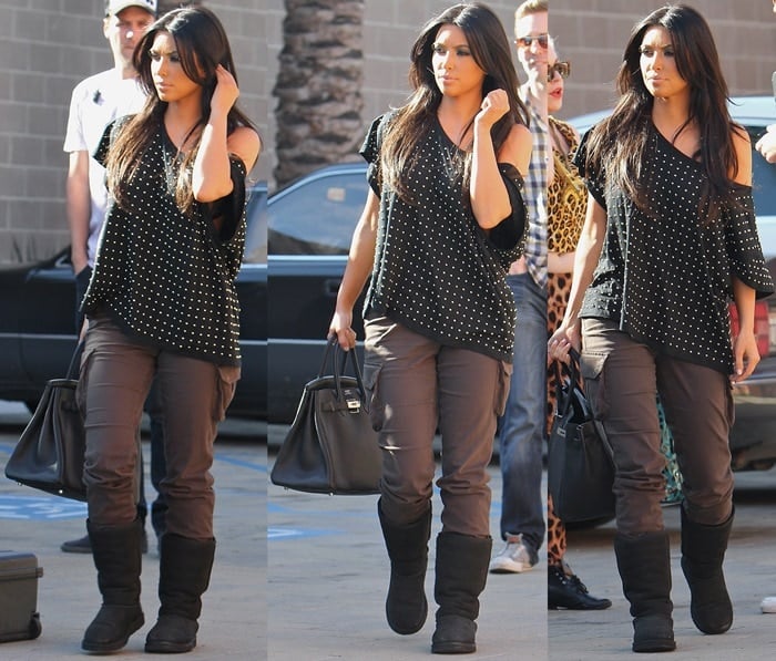 Kim Kardashian styled her black UGG Australia boots with cargo pants by James Jeans, an off-shoulder slouchy black shirt, and a black Hermes Birkin bag