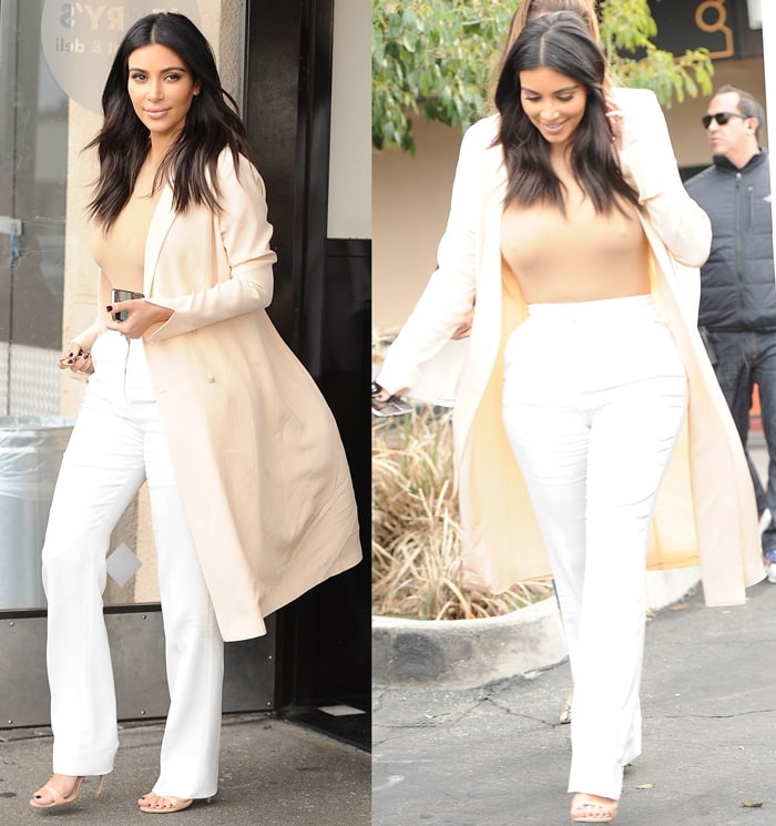 Kim Kardashian wearing a nude bodysuit, white Stella McCartney trousers, a cream coat, and ankle-strap sandals
