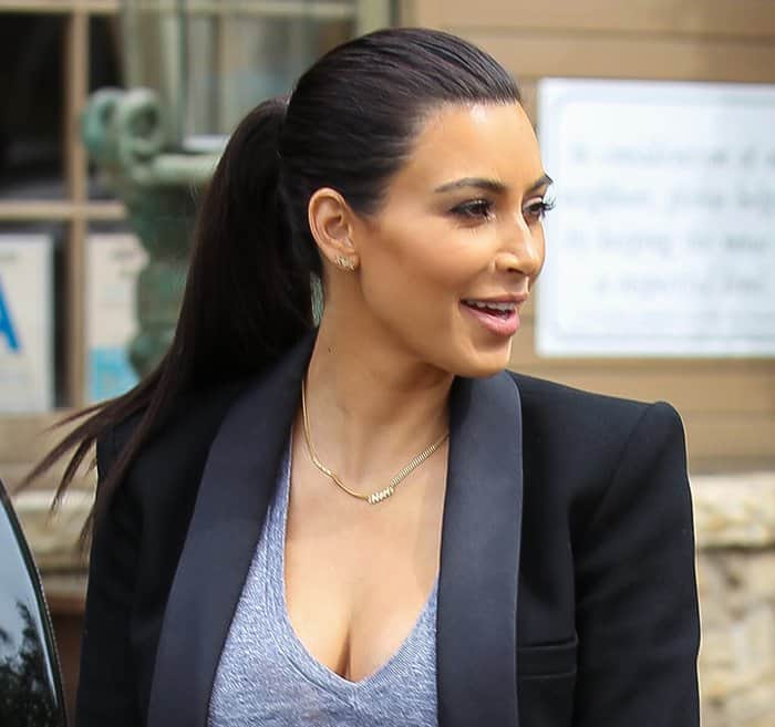 Kim Kardashian exudes effortless style with a sleek ponytail and a chic blazer over a grey top in Los Angeles