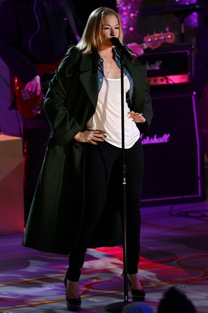 LeAnn Rimes in rehearsal wearing a long green coat over a white top and black trousers
