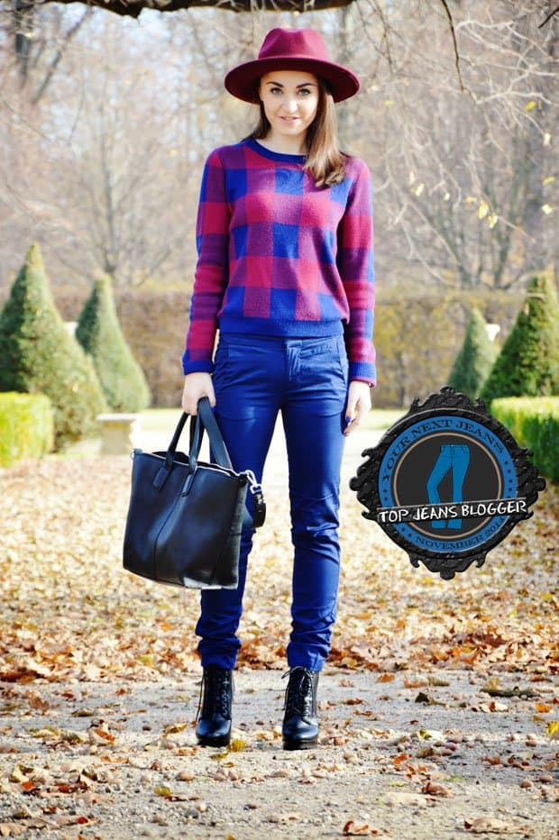 Malwina shows how to wear blue pants with a plaid sweater, a red hat, lace-up boots, and a tote bag