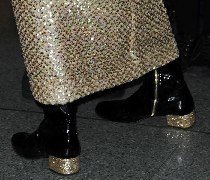 Pixie Lott's black patent boots with partial golden zipper fastenings