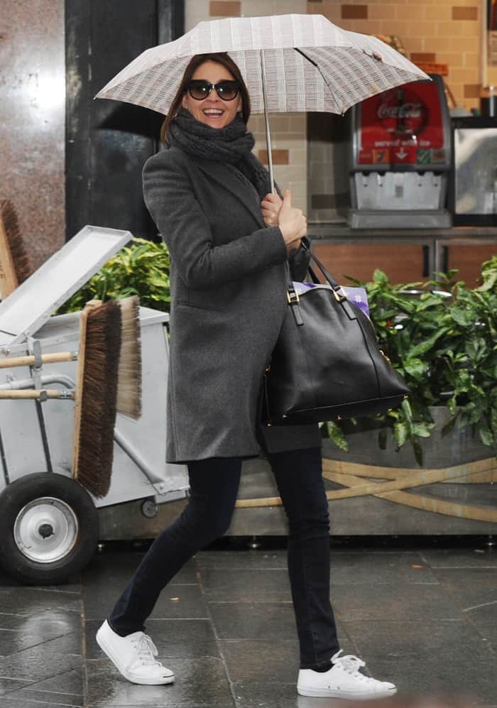 Lisa Snowdon shields herself from the rain as she leaves Capital Radio studios