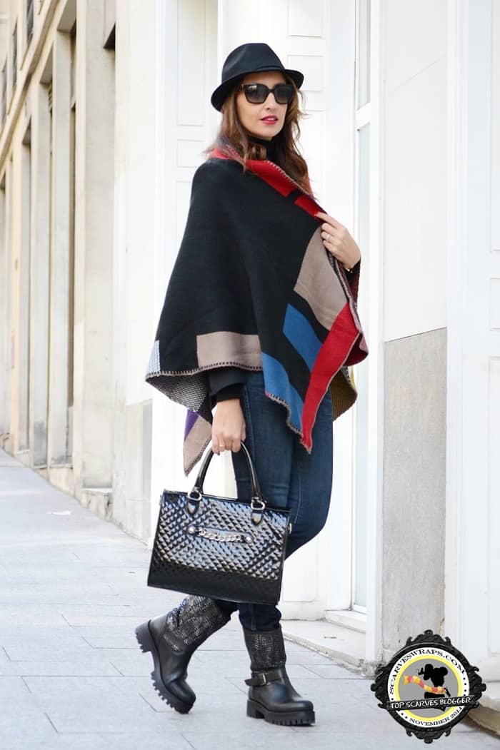 Silvia wore a color-block wrap with boots, jeans, a chic handbag