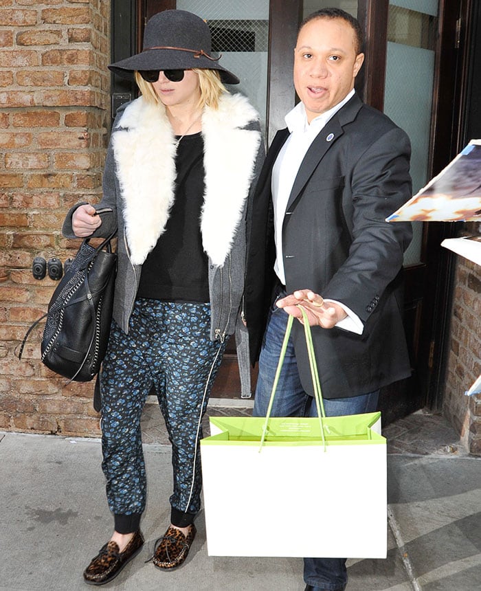 Jennifer Lawrence pairing Pam & Gela printed pull-on pants with Isabel Marant leopard-print moccasins, a cozy IRO shearling coat, a Rag & Bone wide-brim hat, and a studded Coach tote
