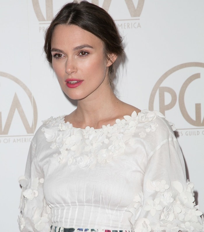 Keira Knightley’s Chanel dress features a whimsical white bodice adorned with delicate 3D floral appliqués and structured pleating at the waist for a soft, romantic silhouette