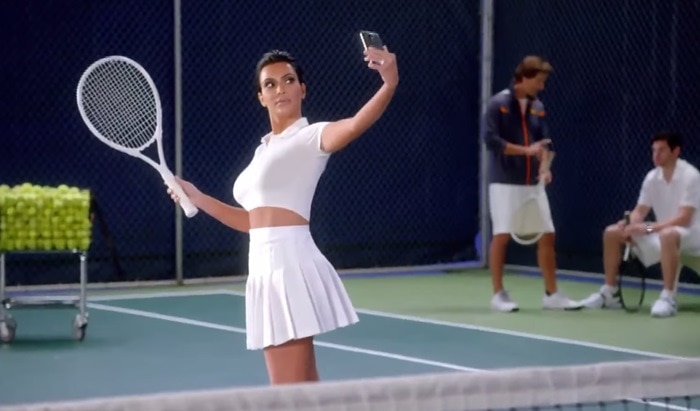 Kim Kardashian takes a selfie while playing tennis in an ad for T-Mobile's "Data Stash" offer