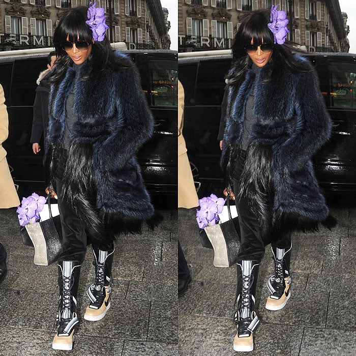 Naomi Campbell wearing a black-and-blue fur coat, black velvet sweatpants, and Nike x Riccardo Tisci Air Force 1 sneaker boots