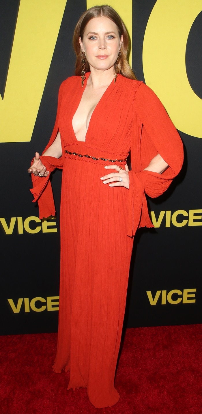 Amy Adams turned heads in a bold, plunging red Chloé pleated gown with statement earrings at the world premiere of Vice at the Samuel Goldwyn Theater in Beverly Hills, California, on December 11, 2018