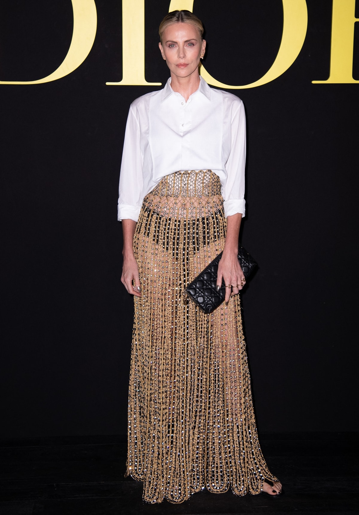 Charlize Theron confidently showcased her high-waisted skirt, layered gracefully over nothing but a pair of sleek black low-rise underwear at the Christian Dior Womenswear Spring/Summer 2024 show during Paris Fashion Week on September 26, 2023, in Paris, France