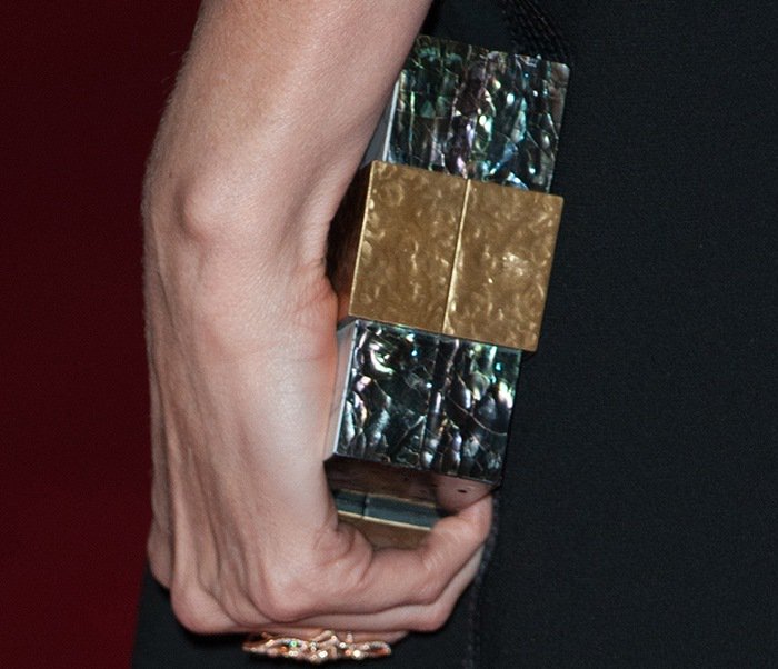 Charlize Theron's Emm Kuo clutch provided a touch of contrast to the all-black ensemble