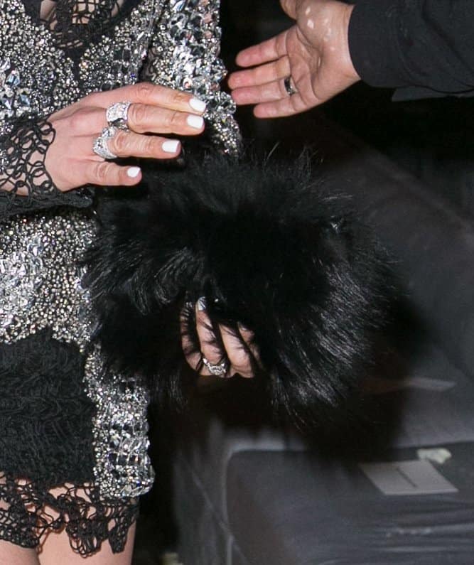 Jennifer Lopez stuns in a dazzling embellished ensemble, accessorizing with a bold black furry clutch that adds texture and drama to her glamorous look