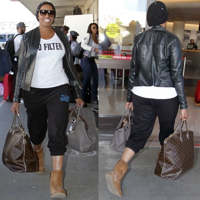 NeNe Leakes in black tracksuit pants toting a Louis Vuitton carryall