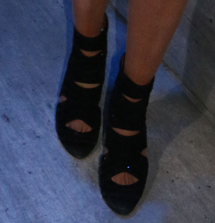 Paris Hilton elevated her look with a pair of towering Alaïa cutout suede booties, featuring bold geometric slits, stud accents, and a sky-high stiletto heel for an edgy yet sophisticated finish