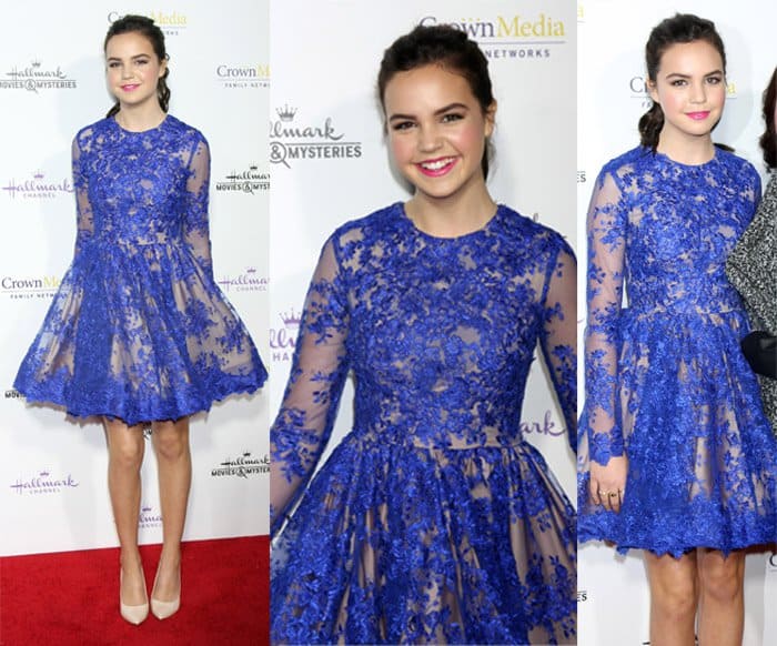 Bailee Madison radiates youthful charm in a royal blue fit-and-flare lace dress, paired with nude-tone heels and a playful ponytail, at the Hallmark TCA Winter Party