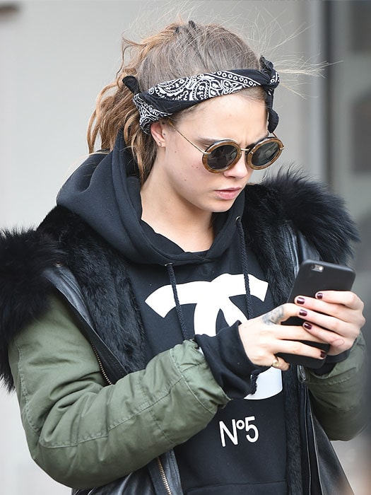 Cara Delevingne keeping herself engrossed with her phone to ignore the paparazzi