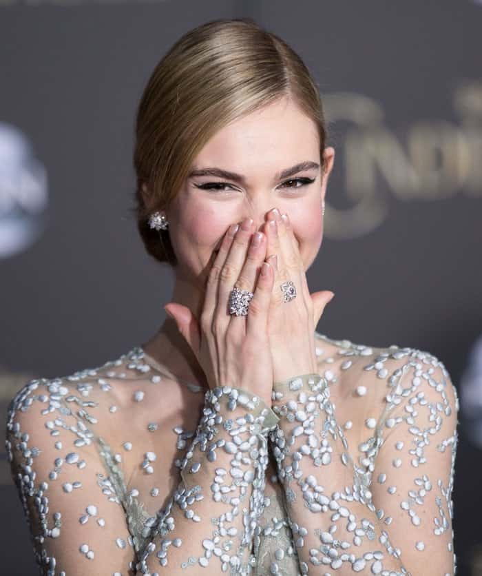 Lily James complements her stunning gown with sparkling diamond earrings and rings