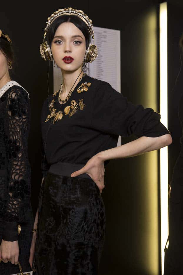 Model showcases Dolce & Gabbana's luxurious, stone-embellished headphones at a fashion event, blending high fashion with cutting-edge audio technology