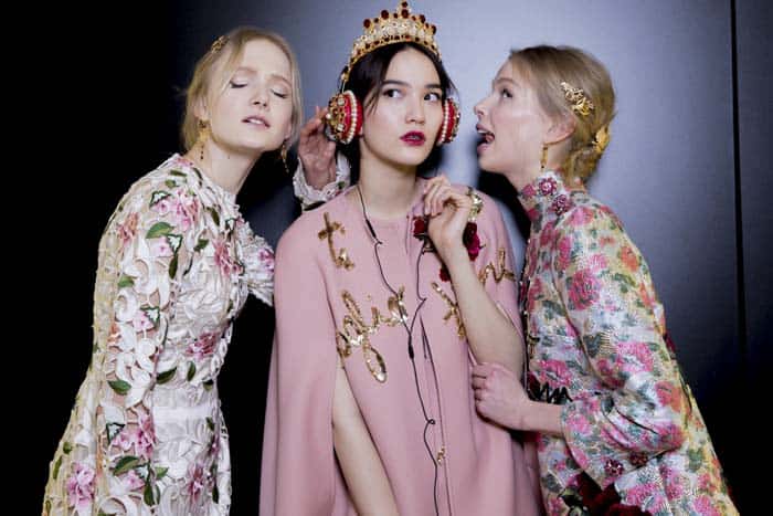 Models display Dolce & Gabbana's red nappa leather headphones adorned with Swarovski crystals and pearls backstage at the Fall 2015 show in Milan