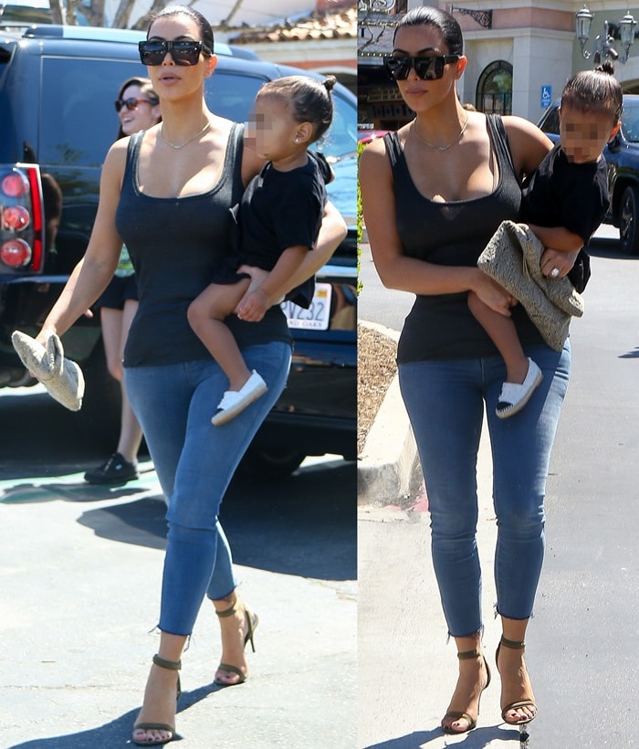 Kim Kardashian in a sheer top with tight faded jeans