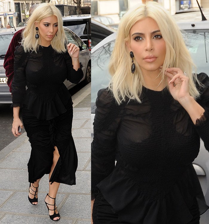 Kim Kardashian wears a high-necked peplum blouse with dark sheer detailing