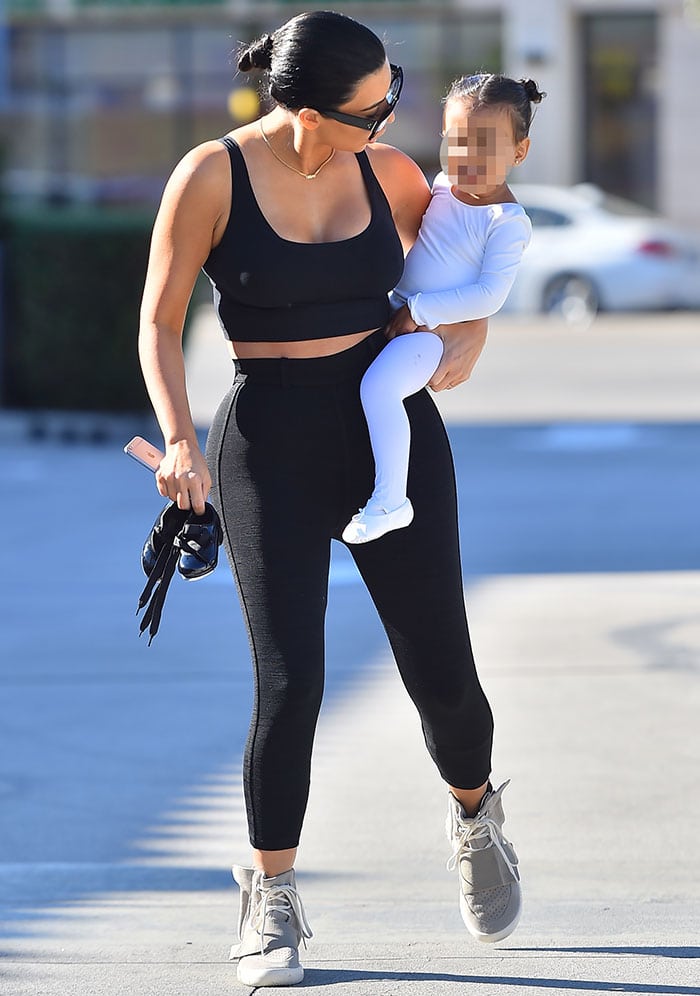 Kim Kardashian in a black crop top and leggings