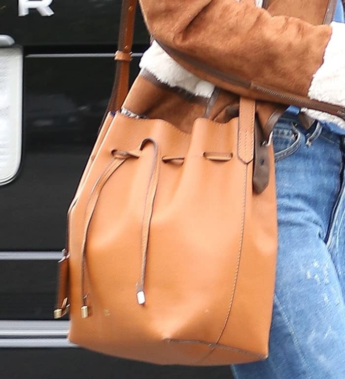 Alessandra Ambrosio toting her highly coveted Mansur Gavriel bucket bag, a minimalist yet timeless accessory that has remained a celebrity favorite for its sleek design and everyday versatility