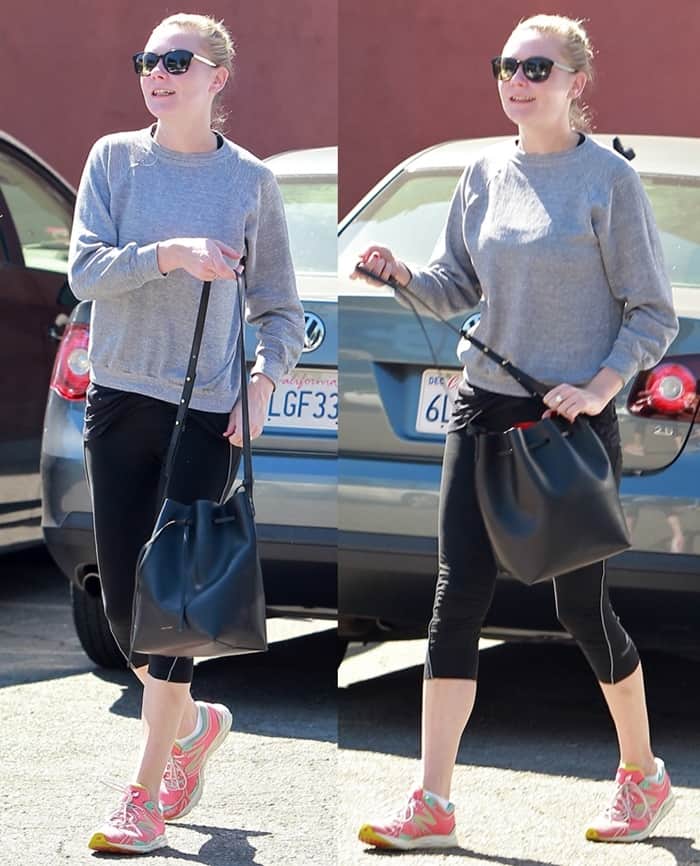 Kirsten Dunst keeps it effortlessly sporty while heading to the gym in Los Angeles on October 16, 2013, wearing a casual gray sweatshirt, cropped leggings, colorful sneakers, and a sleek black Mansur Gavriel bucket bag