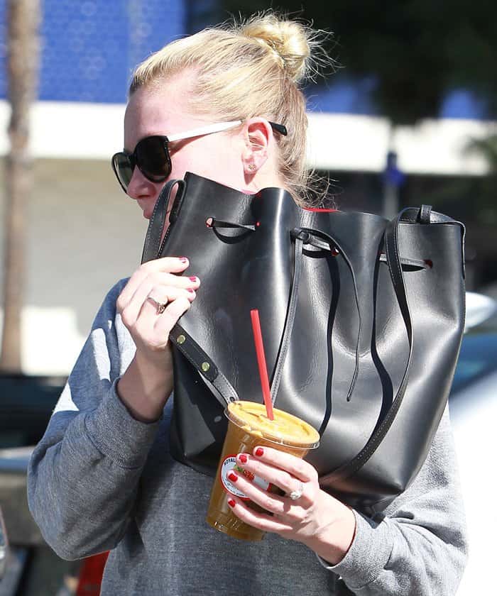 Kirsten Dunst carrying her sleek black Mansur Gavriel bucket bag, a cult-favorite known for its structured yet minimalist design that seamlessly blends fashion and function