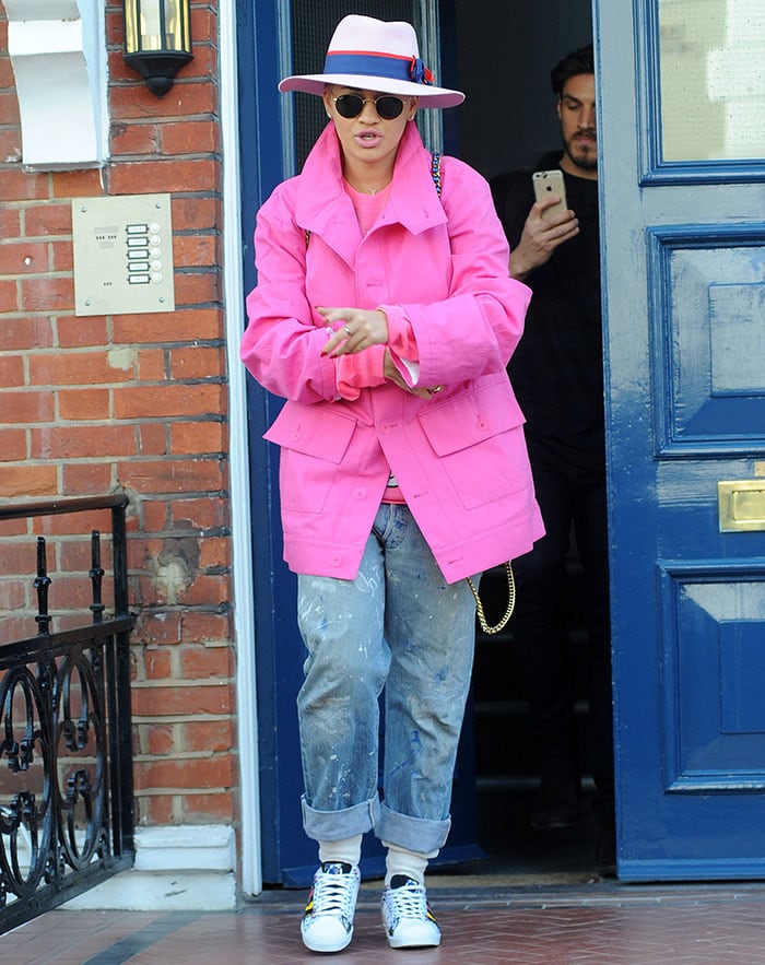 Rita Ora turned heads in her Rita Ora x Adidas Superstar sneakers, Maison Michel trilby hat, Ray-Ban round sunglasses, and a metallic blue vintage Chanel backpack