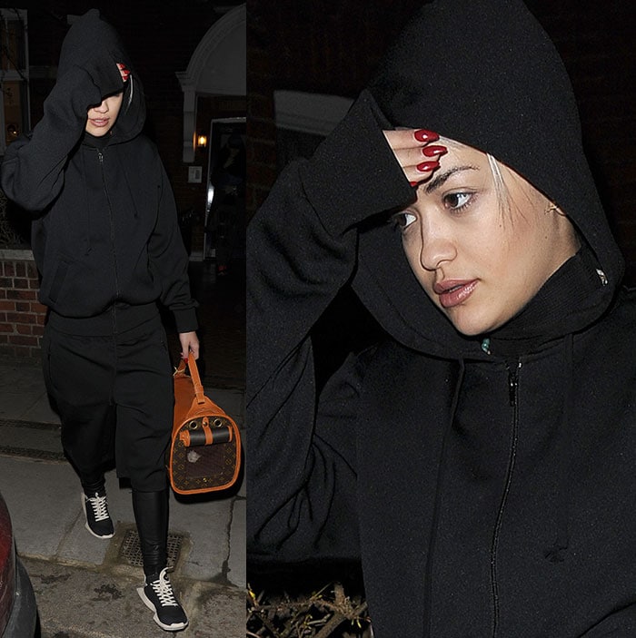 Rita Ora wears a black tracksuit with a hoodie and knee-length shorts