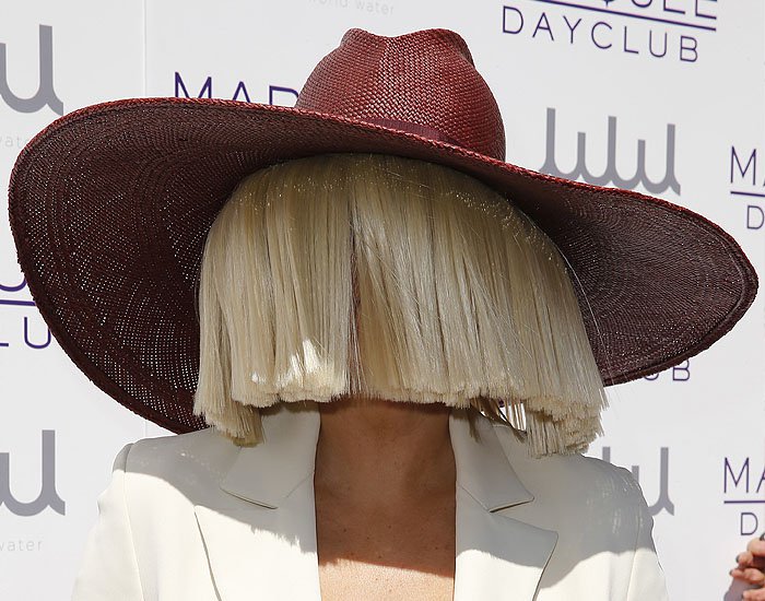 A gust of wind threatening to show Sia's hidden face