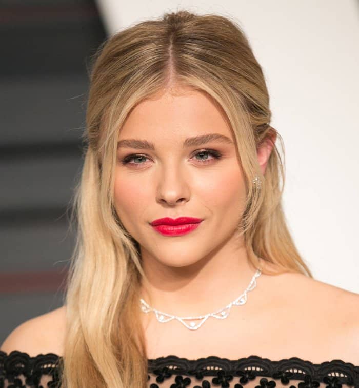 Chloë Grace Moretz looks stunning with her sleek, parted hairstyle and bold red lips, highlighting her fresh and glamorous look at the 2015 Vanity Fair Oscar Party