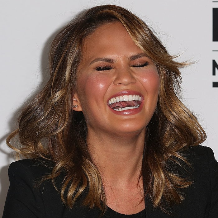 Chrissy Teigen laughing heartily at a joke during the Twitter press conference