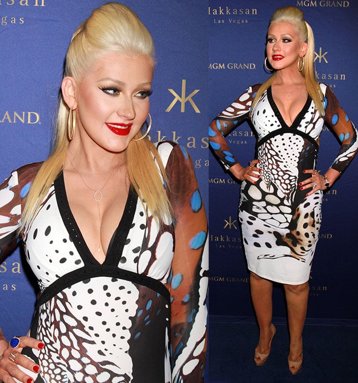 Christina Aguilera exudes retro glamour with a sleek pompadour hairstyle, bold winged eyeliner, and a classic red lip, perfectly complementing her edgy yet sophisticated look