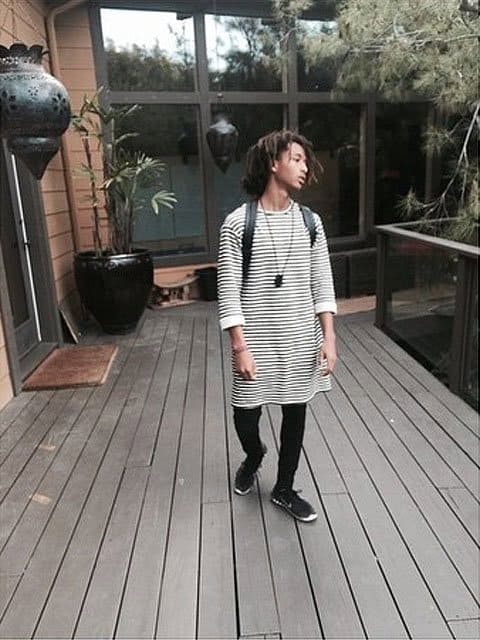 Jaden Smith rocks a black-and-white striped sweater dress with black skinny jeans, effortlessly blending gender-neutral fashion with casual style