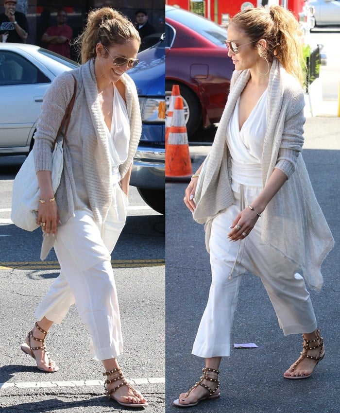 Jennifer Lopez keeps it chic and comfortable in an all-white ensemble, accessorized with Valentino Rockstud gladiator sandals