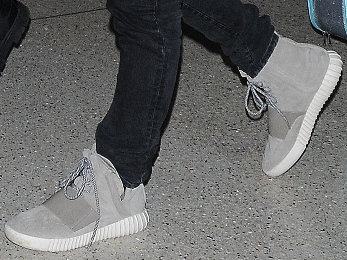 Kanye West wearing his own design, the adidas x Kanye West "Yeezy 750 Boost" sneakers