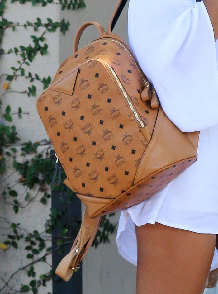 Karrueche Tran's cognac MCM backpack featuring the brand's iconic monogram print and sleek leather details