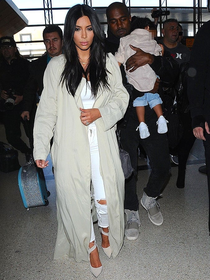 The Wests making their way through a throng of paparazzi inside LAX