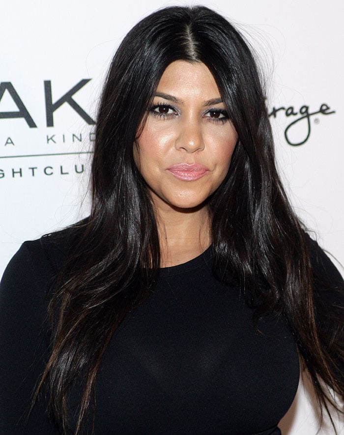 Kourtney Kardashian let her long raven tresses fall loosely over her shoulders