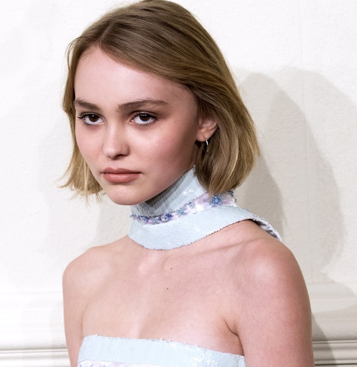 Lily-Rose Depp tucks her hair behind her ears at the Chanel Paris-Salzburg 2014/15 Metiers d'Art Collection