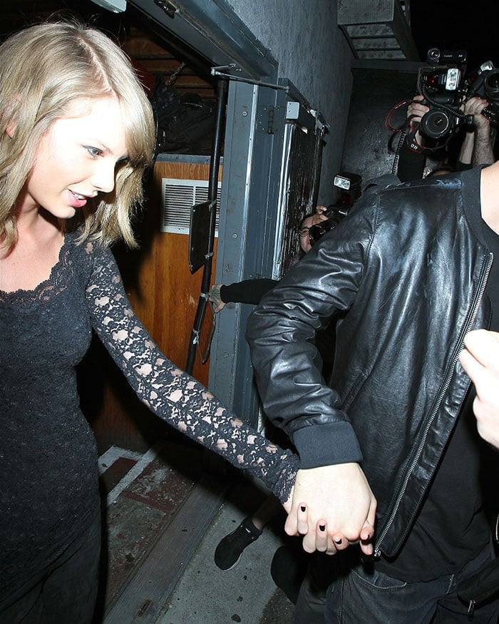 Taylor Swift and Calvin Harris holding hands as they leave rock band Haim's concert at The Troubadour club