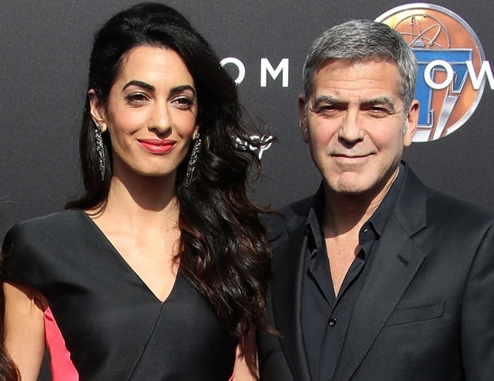 Amal Clooney wears her hair down at the premiere of "Tomorrowland" as she poses with husband George Clooney