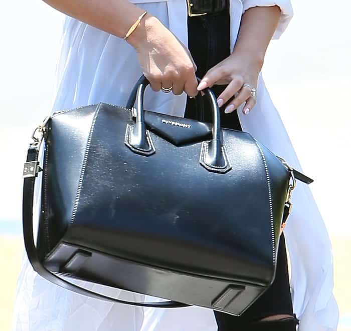 Chrissy Teigen carrying an expensive Givenchy leather handbag