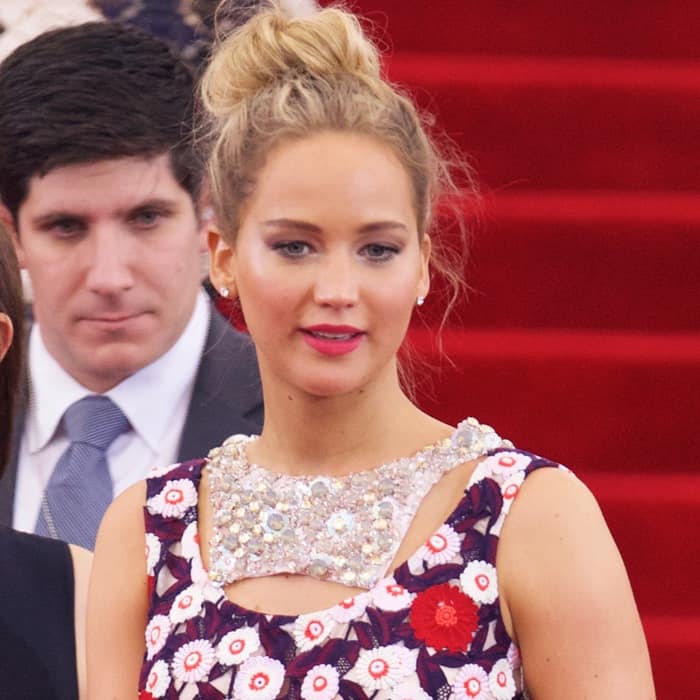 Jennifer Lawrence looks radiant with a soft updo hairstyle and fresh, natural makeup featuring pink lips and subtle eye makeup at the 2015 Met Gala